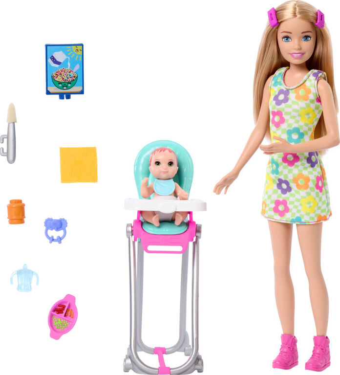 Barbie doll with baby in high chair and accessories on a white background
