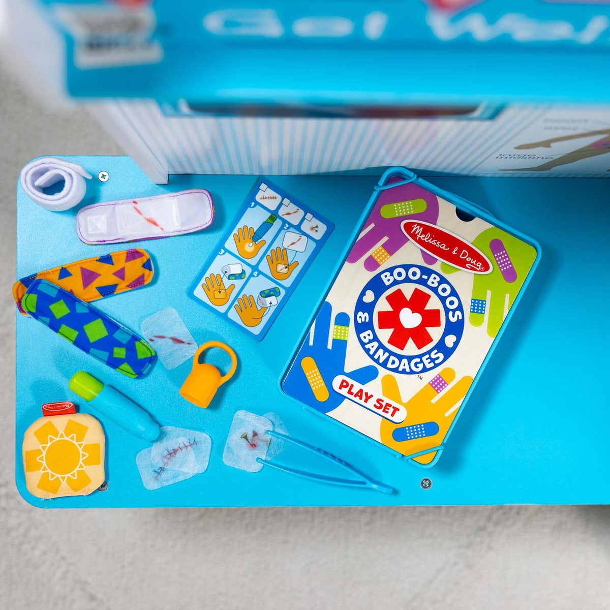 Boo-Boos & Bandages play set with various accessories on a blue surface.