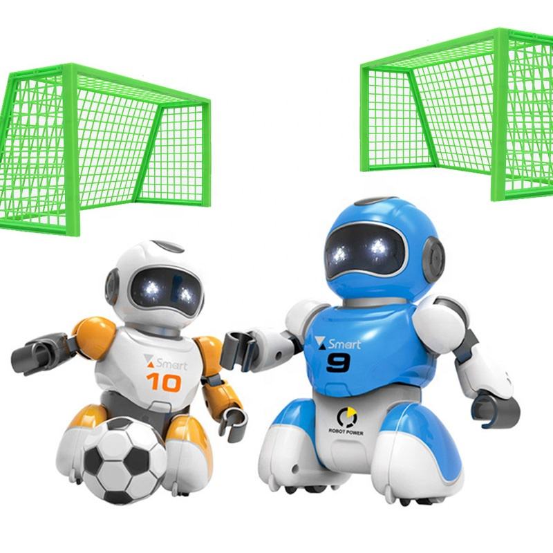 Two toy robots, one white and orange, the other blue and black, with soccer balls and green goals in the background.